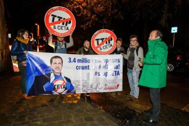 Protesters hold up a placard reading '3.4 million Europeans count on Wallonia - stop CETA' as a meeting on CETA takes place at the Walloon parliament in Namur, Belgium
