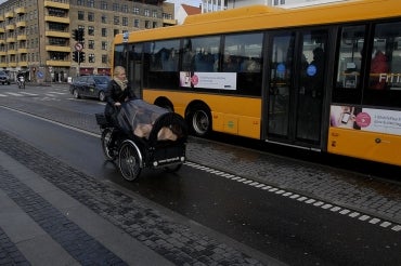 A female cyclist and a bus in Copenhagen