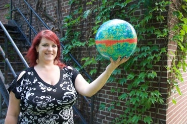 Renée Hložek holding a globe