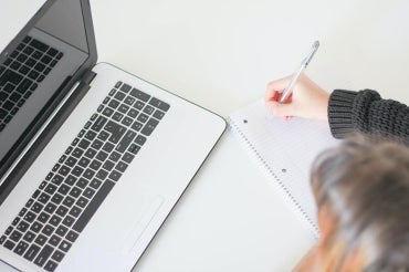 A person sit in front of a laptop