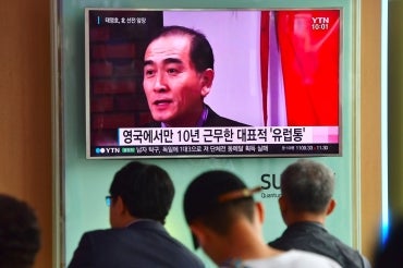 People watch a television news broadcast showing file footage of Thae Yong-Ho, North Korea's deputy ambassador to Britain