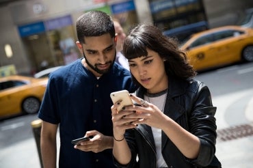 Two people playing Pokémon GO outside the Nintendo flagship store in New York