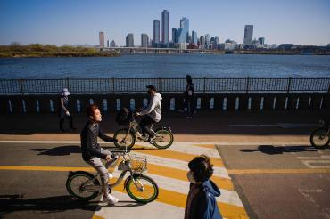 people cycling in seoul korea with a clear blue sky