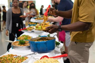 A student piles his plate high with plant based food from the buffet being served at a workshop focused on cooking plant-based food