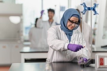 woman in a hijab conducting an experiment in a lab at U of T