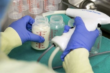 Breast milk being fed into an analyzer