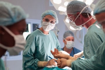 a female surgeon with colleagues in an operating room