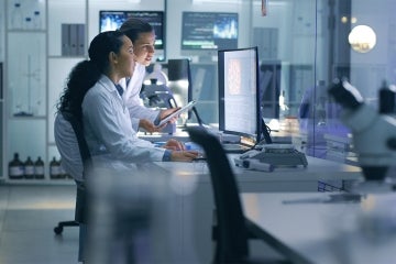 two doctors look at a computer screen in a hospital setting