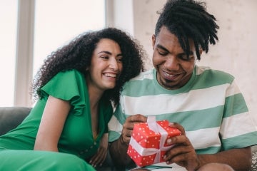 A man opens a gift received from his partner