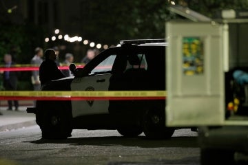 a police officer stands guard behind police tape at a police involved shooting