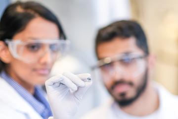 Pranav Kadhiresan and Buddhisha Udugama hold up the pea-sized heating device