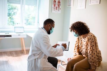 a doctor explains something to a patient in a primary care clinic