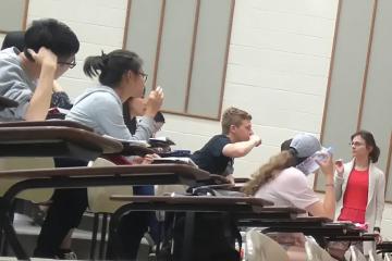 Insturctor Alex Motut and some of her students in a lecture hall