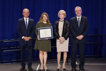 Photo of Barbara Dick receiving award from president and chancellor