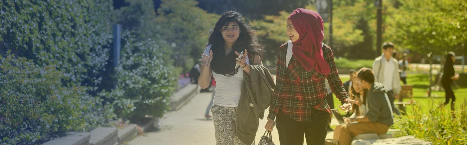 Two students walking outside on the UTSC campus.