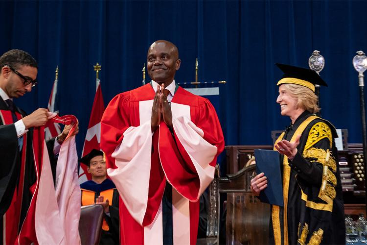 Wesley Hall puts his hands together in thanks as he is about to be hooded by Walied Soliman