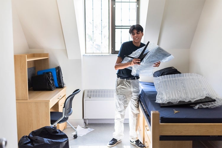 a male student moves into his dorm room at the University of Toronto