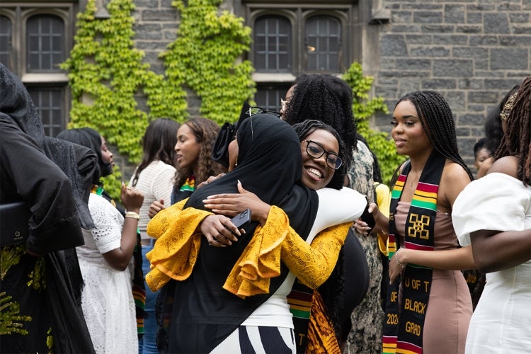 Graduands embrace in the Hart House quad following the ceremony