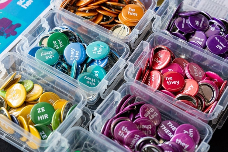 an assortment of colored pins indicating pronouns